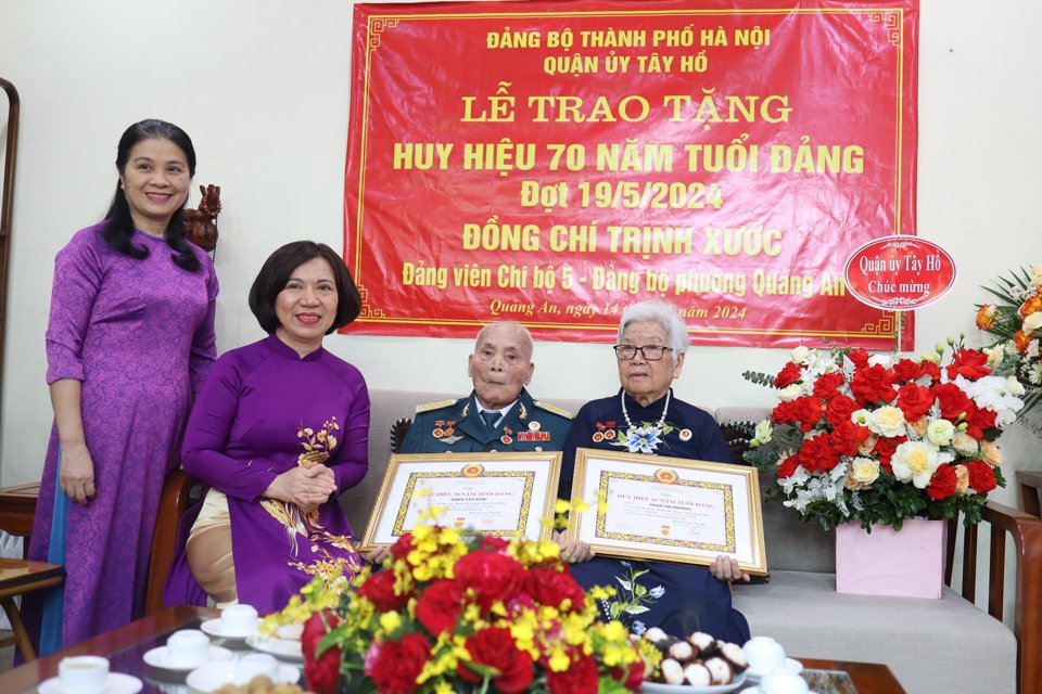 B&iacute; thư Quận uỷ T&acirc;y Hồ L&ecirc; Thị Thu Hằng trao Huy hiệu Đảng cho vợ chồng đồng ch&iacute; Trịnh Văn Xước.