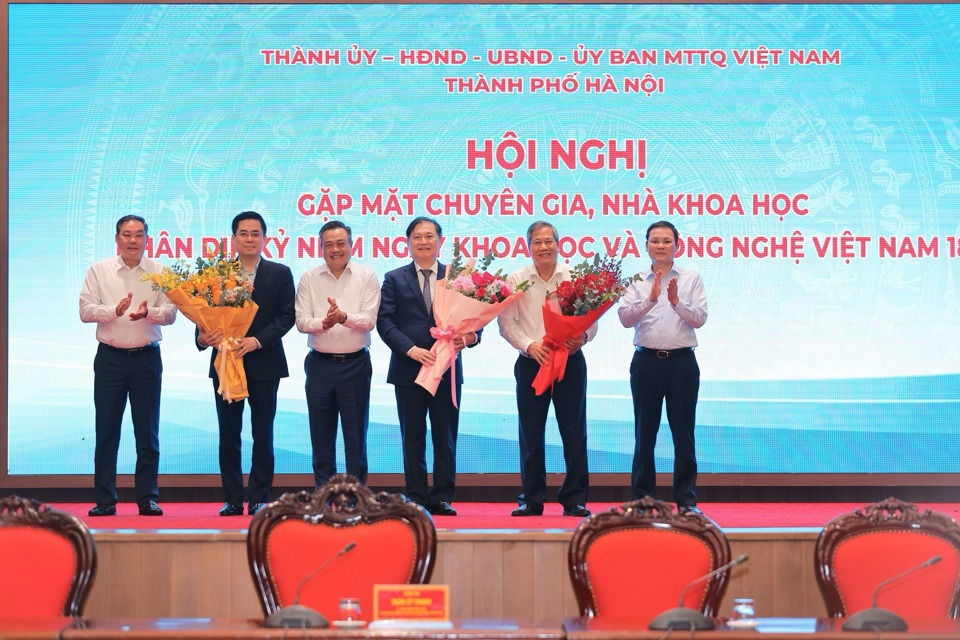 Latilde;nh đạo TP Hagrave; Nội tặng hoa chuacute;c mừng đại diện đội ngũ chuyecirc;n gia, nhagrave; khoa học.