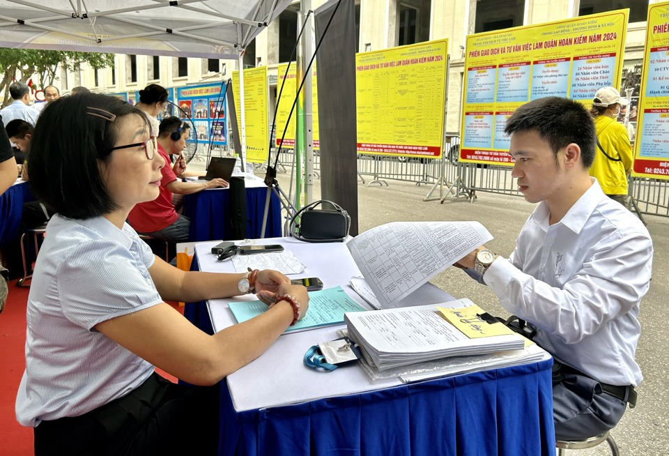 C&aacute;n bộ Trung t&acirc;m Dịch vụ việc l&agrave;m H&agrave; Nội đang cung cấp th&ocirc;ng tin c&aacute;c vị tr&iacute; việc l&agrave;m cho người lao động. Ảnh: Trần Oanh.