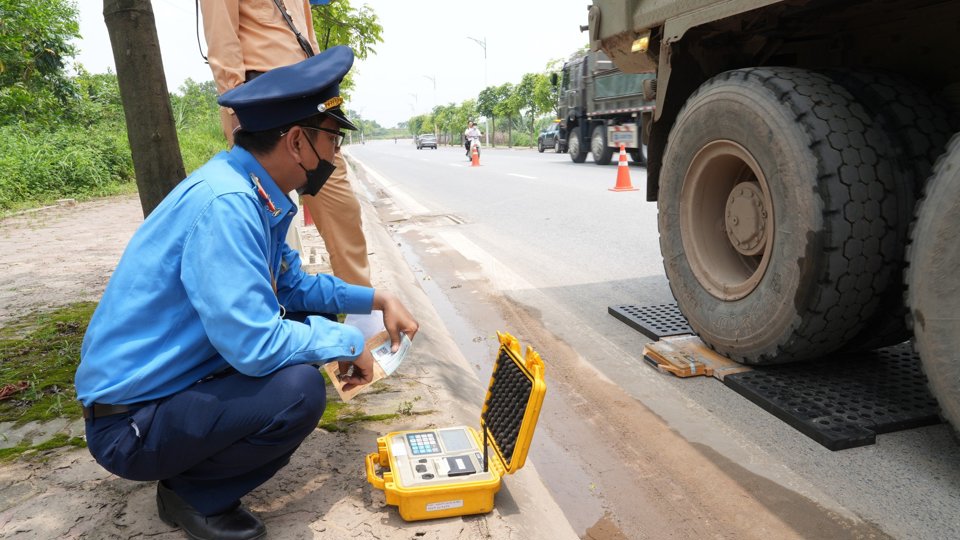 Lực lượng li&ecirc;n ng&agrave;nh tiến h&agrave;nh c&acirc;n trọng tải của c&aacute;c xe chở vật liệu x&acirc;y dựng.