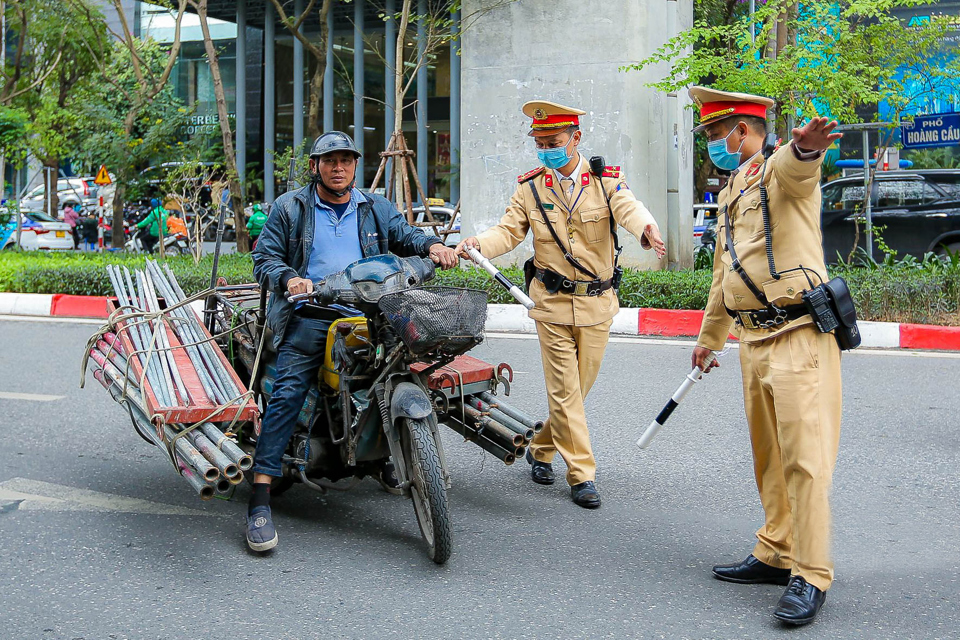 Lực lượng chức năng kiểm tra, xử lý trường hợp xe thô sơ, xe ba gác chở vật liệu, sắt thép, tôn… cồng kềnh. Ảnh: Hữu Thắng