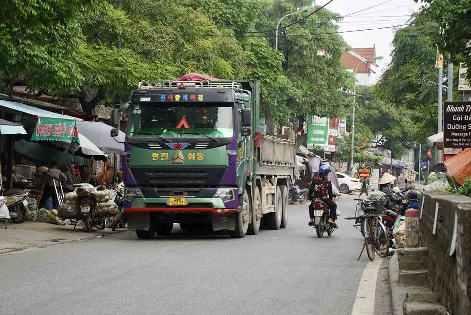 Xe tải, container rầm rập chạy l&agrave; cảnh tượng thường xuy&ecirc;n diễn ra tr&ecirc;n Quốc lộ 21B đoạn qua huyện Ứng H&ograve;a. Ảnh: Hữu Ch&aacute;nh