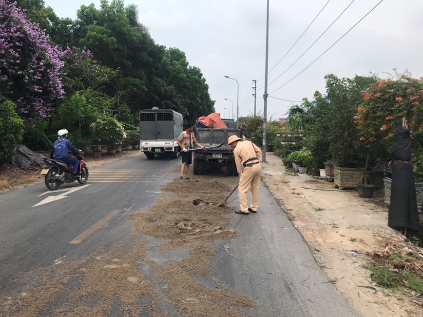 &nbsp;Lực lượng CSGT phối hợp với c&ocirc;ng ty m&ocirc;i trường xử l&yacute; vết dầu loang tr&ecirc;n đường.