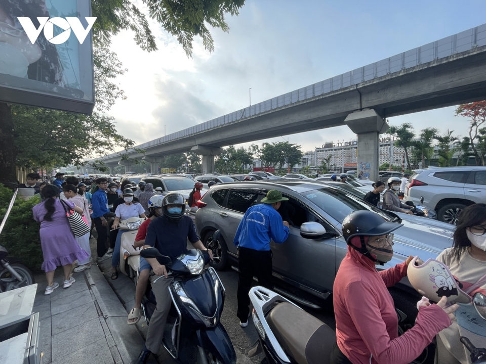 H&agrave;ng trăm phụ huynh học sinh đứng đợi con trước cổng trường mặc d&ugrave; được c&aacute;c bạn sinh vi&ecirc;n t&igrave;nh nguyện của trường ra sức k&ecirc;u gọi kh&ocirc;ng tập trung đ&ocirc;ng người.