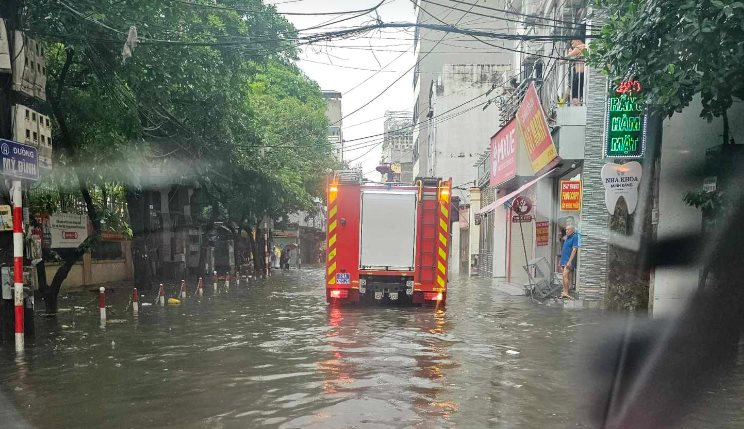 Xe cứu hoả qua đoạn đường mưa ngập v&agrave;o hiện trường.