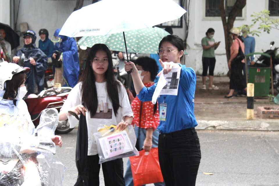 Thanh niên tình nguyện che ô, nhiệt tình hỗ trợ thí sinh.