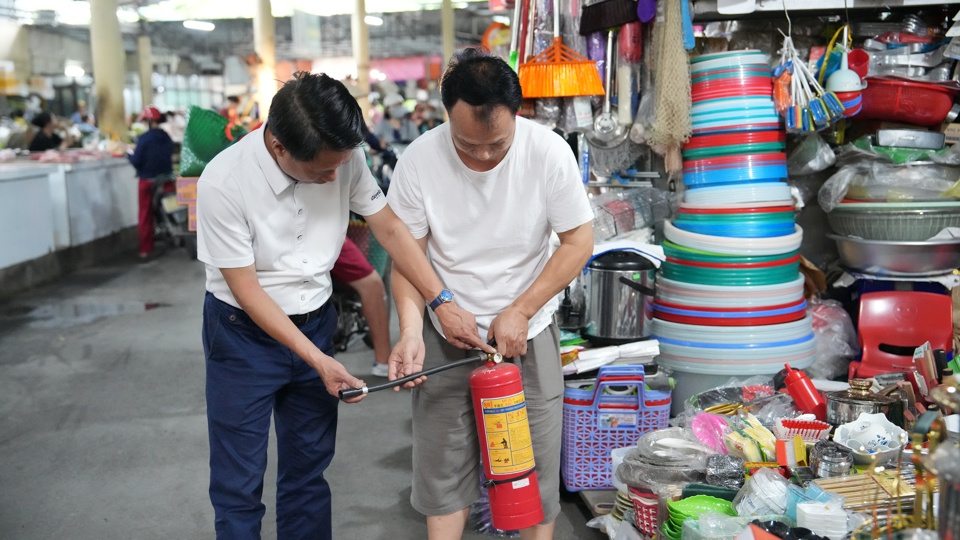 Lực lượng chức năng kiểm tra c&aacute;c trang thiết bị ph&ograve;ng ch&aacute;y chữa ch&aacute;y tại một ki ốt trong chợ Xu&acirc;n La.