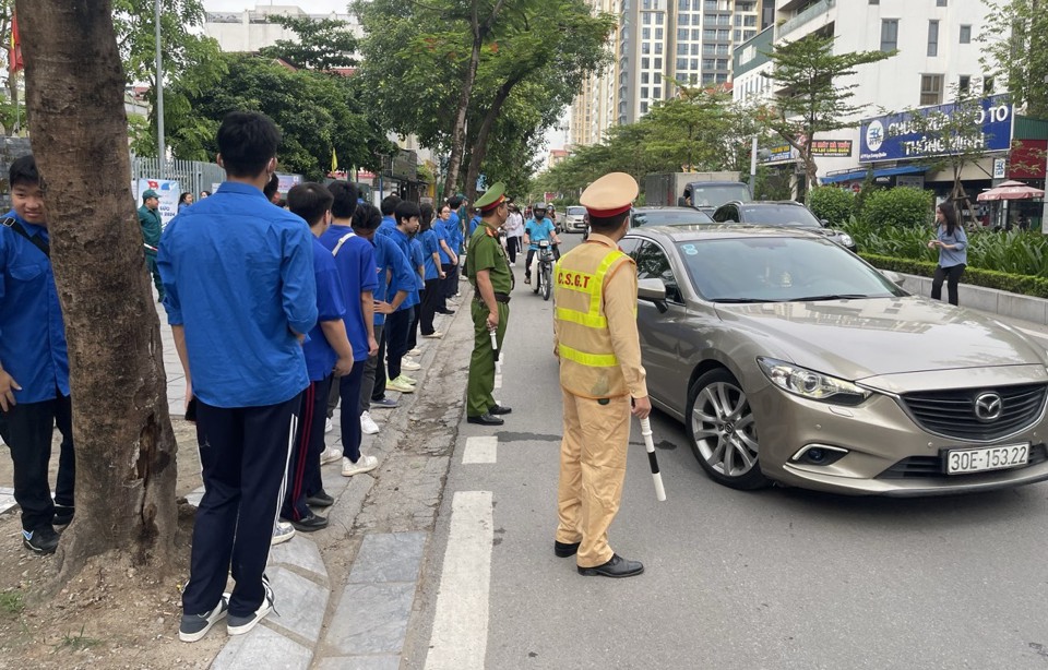 Lực lượng chức năng quận T&acirc;y Hồ l&agrave;m nhiệm vụ tổ chức hướng dẫn giao th&ocirc;ng tại điểm thi trường THCS Nhật T&acirc;n.