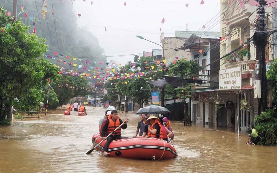 Nhiều tuyến đường của TP H&agrave; Giang bị ngập s&acirc;u trong lũ, lực lượng chức năng phải dung thuyền cao su để di chuyển người d&acirc;n. Ảnh: C&ocirc;ng an H&agrave; Giang.