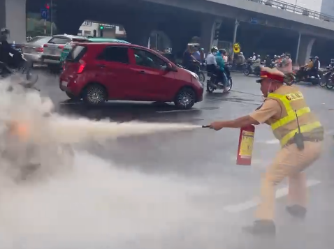 Cảnh s&aacute;t giao th&ocirc;ng d&ugrave;ng b&igrave;nh chữa ch&aacute;y mini dập lửa.