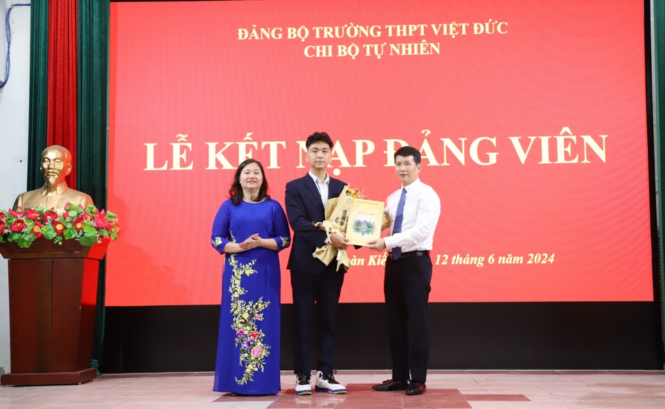 Ph&oacute; Trưởng Ban Tổ chức Th&agrave;nh ủy H&agrave; Nội Triệu Thị Ngọc v&agrave; Chủ tịch UBND quận Ho&agrave;n Kiếm Phạm Tuấn Long trao quyết định v&agrave; tặng hoa ch&uacute;c mừng t&acirc;n đảng vi&ecirc;n Ho&agrave;ng Nam Kh&aacute;nh.