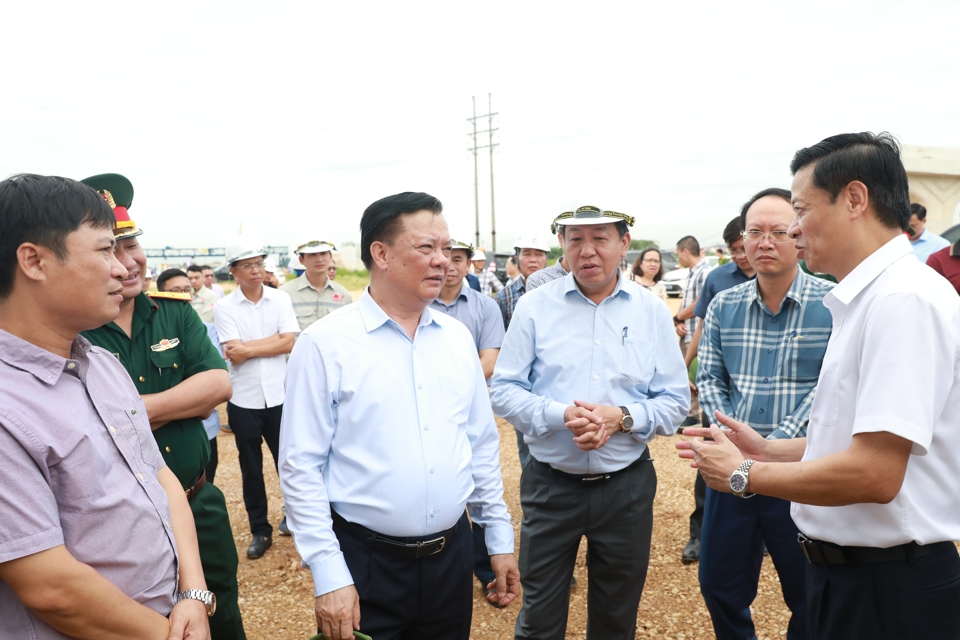 Ủy Bộ Chính trị, Bí thư Thành ủy Hà Nội Đinh Tiến Dũng nghe báo cáo những khó khăn, vướng mắc liên quan đến Dự án đường Vành đai 4 - Vùng Thủ đô tại công trường thi công đường song hành. Ảnh: Thanh Hải