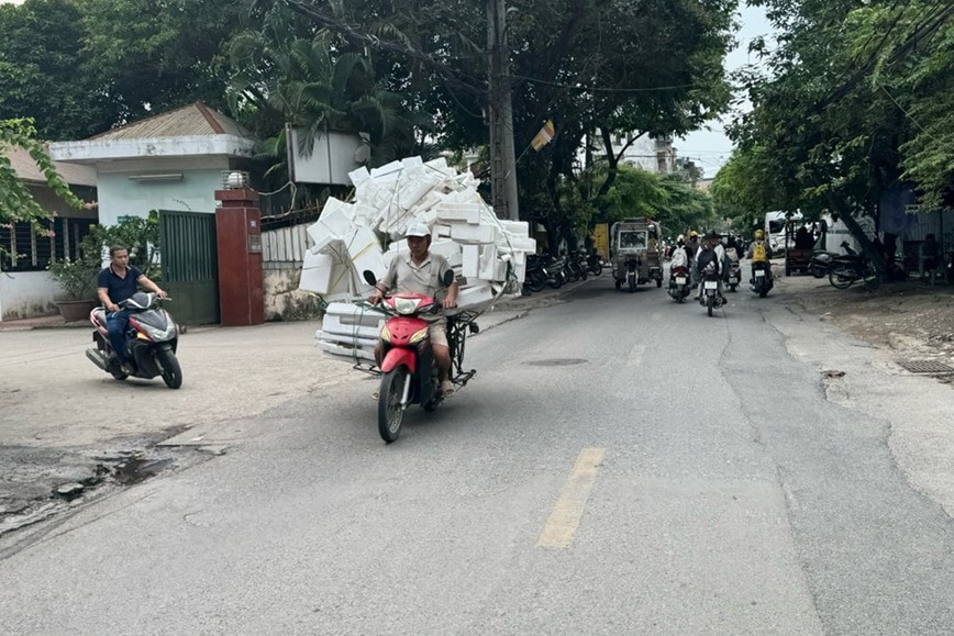 Người đ&agrave;n &ocirc;ng điều khiển xe m&aacute;y với đống th&ugrave;ng xốp chồng chất lộn xộn tr&ecirc;n phố Vĩnh Hưng.