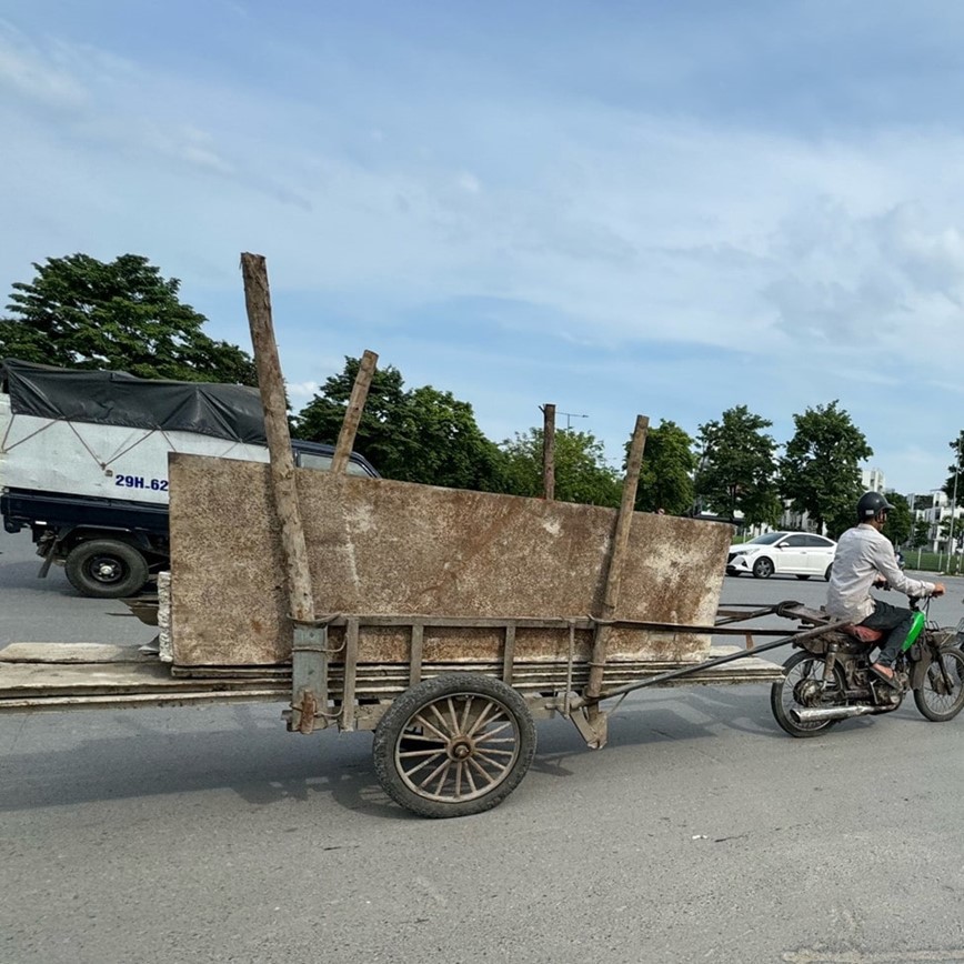 Chiếc xe m&aacute;y c&oacute; th&ecirc;m phần xe k&eacute;o ph&iacute;a sau, chở sắt kh&ocirc;ng được che đậy cẩn thận lưu th&ocirc;ng qua đường Phạm Tu.