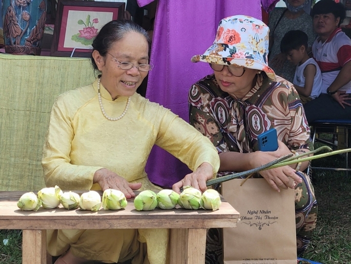 Nghệ nh&acirc;n Phan Thị Thuận tr&igrave;nh diễn thao t&aacute;c r&uacute;t tơ sen tại Festival Nghề truyền thống Huế năm 2023. Ảnh: Thanh Hương &nbsp;