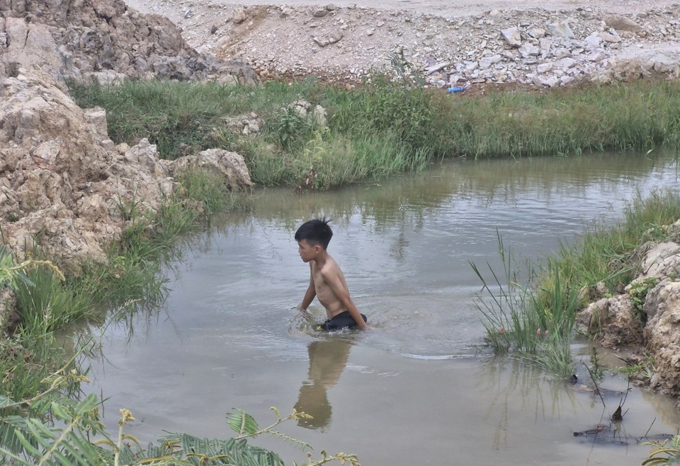 C&oacute; em lội dưới hố s&acirc;u tại ch&acirc;n c&ocirc;ng tr&igrave;nh