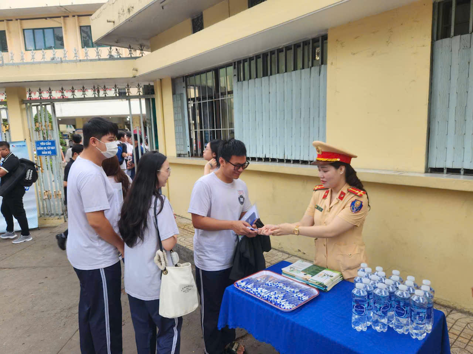 Lực lượng t&igrave;nh nguyện vi&ecirc;n hỗ trợ b&uacute;t viết cho c&aacute;c em trước khi v&agrave;o ph&ograve;ng thi. Ảnh: Nam Thương