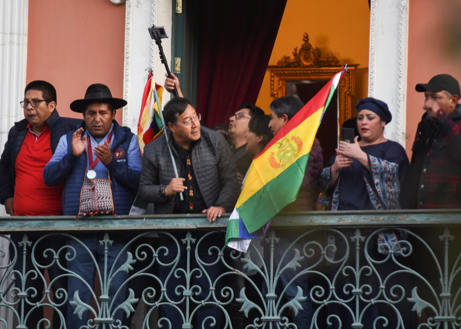 Tổng thống Bolivia, &ocirc;ng&nbsp;Luis Arce vẫy cờ từ ban c&ocirc;ng sau khi t&igrave;nh h&igrave;nh ổn định (thứ ba từ tr&aacute;i sang). Ảnh: Claudia Morales&nbsp;