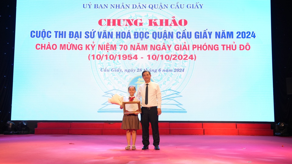 &Ocirc;ng Nguyễn Minh Cường - Trưởng Ph&ograve;ng VHTT quận Cầu Giấy trao giải Nhất cuộc thi Đại sứ văn ho&aacute; đọc cho em Lại Hồng V&acirc;n - Lớp 3M, Trường Tiểu học Nghĩa T&acirc;n.