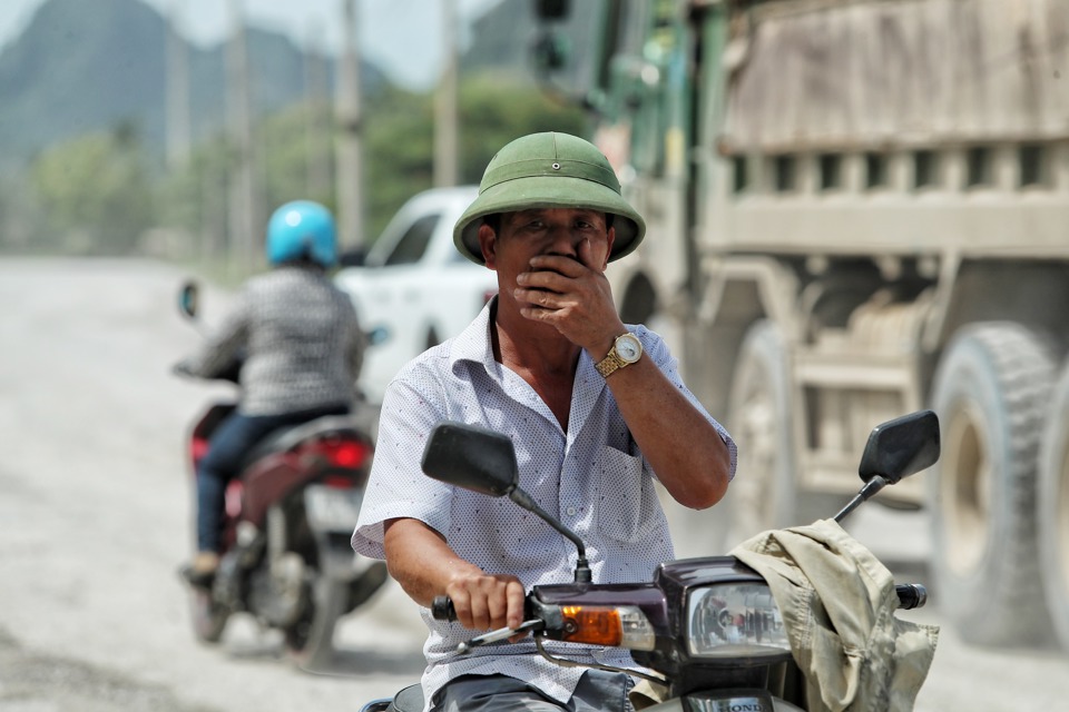 Người d&acirc;n đi qua đ&acirc;y qu&ecirc;n kh&ocirc;ng đeo khẩu trang phải lấy tay che mặt.