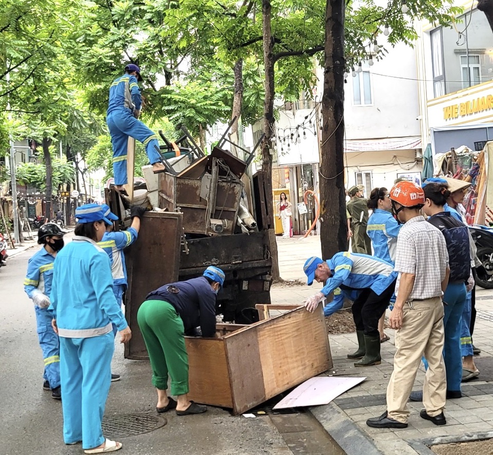 C&ocirc;ng nh&acirc;n vệ sinh m&ocirc;i trường tổ chức thu dọn&nbsp;vật liệu phế thải dọc tuyến phố Nguyễn Văn Tuyết.&nbsp;