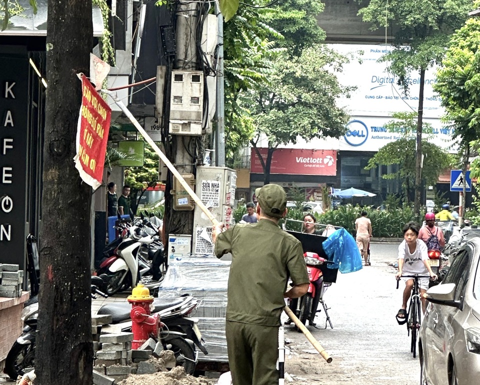 Lực lượng chức năng dỡ bỏ quảng c&aacute;o kh&ocirc;ng đ&uacute;ng quy định tại tuyến phố&nbsp;Nguyễn Văn Tuyết.