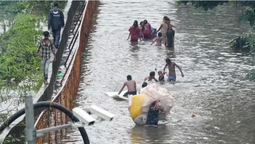 Người d&acirc;n đi qua một con phố ngập nước ở Mumbai v&agrave;o thứ Hai, ng&agrave;y 8 th&aacute;ng 7, sau trận mưa lớn. Ảnh: PTI