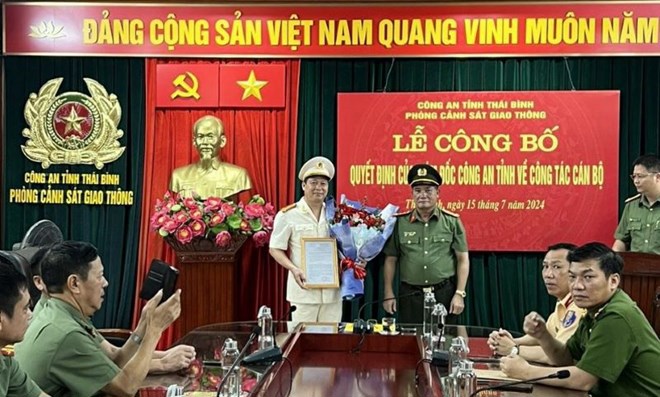 Đại t&aacute; Phạm Đ&igrave;nh T&acirc;m - Ph&oacute; Gi&aacute;m đốc C&ocirc;ng an tỉnh Th&aacute;i B&igrave;nh trao quyết định, tặng hoa ch&uacute;c mừng Trung t&aacute; Nguyễn H&ograve;a Hiệp. Ảnh: C&ocirc;ng an tỉnh Th&aacute;i B&igrave;nh