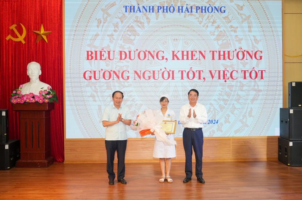 Bí thư Thành ủy Lê Tiến Châu cùng Phó Chủ tịch UBND thành phố Lê Khắc Nam tặng Bằng khen và hoa biểu dương Điều dưỡng Nguyễn Thị Thảo.