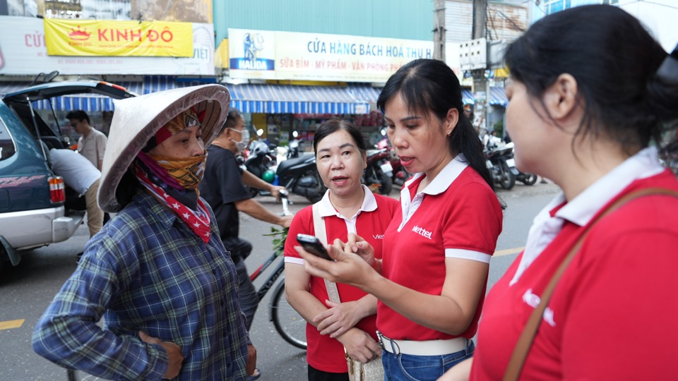 Nh&acirc;n vi&ecirc;n Viettel hỗ trợ người d&acirc;n c&ocirc;ng t&aacute;c chuyển đổi mạng, để thực hiện c&aacute;c hoạt động giao dịch kh&ocirc;ng d&ugrave;ng tiền mặt.