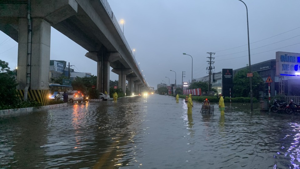 Khu vực bến xe Y&ecirc;n Nghĩa ngập trong nước, c&ocirc;ng nh&acirc;n tho&aacute;t nước ứng trực l&agrave;m nhiệm vụ đẩy nhanh tốc độ ti&ecirc;u tho&aacute;t nước.