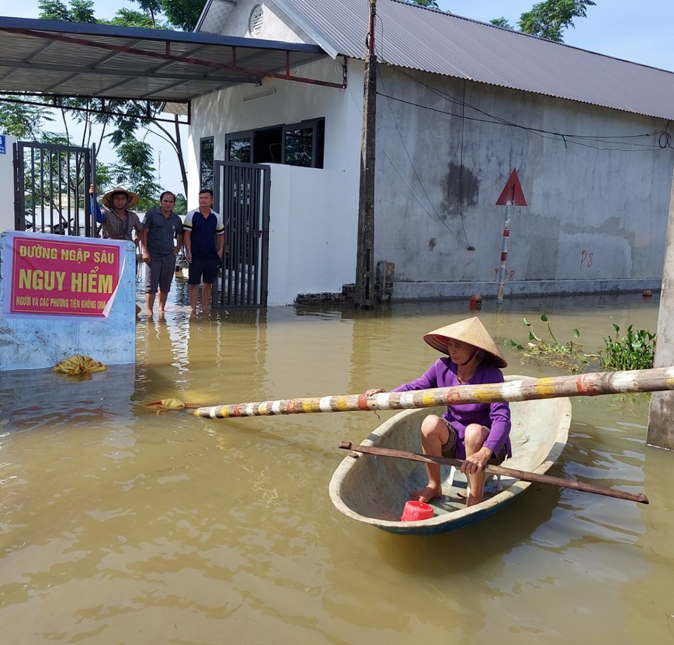 Người d&acirc;n th&ocirc;n Nh&acirc;n L&yacute;, x&atilde; Nam Phương Tiến b&igrave; b&otilde;m trong nước lũ.