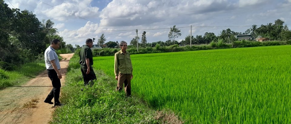 Thương binh Nguyễn Trọng Miền (trước) c&ugrave;ng c&aacute;n bộ huyện Ea Kar thăm m&ocirc; h&igrave;nh l&uacute;a nước của gia đ&igrave;nh.