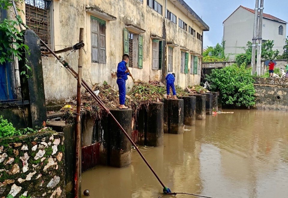 C&ocirc;ng nh&acirc;n vớt r&aacute;c tạo d&ograve;ng chảy ti&ecirc;u tho&aacute;t nước chống &uacute;ng ngập tại Trạm bơm An Vọng (huyện Chương Mỹ).