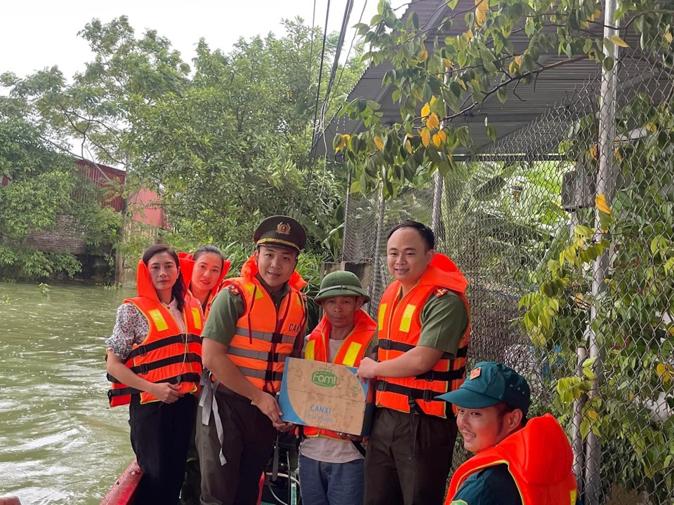 Lực lượng c&ocirc;ng an bơi thuyền v&agrave;o "rốn lũ" tiếp tế m&igrave; t&ocirc;m, sữa, nước uống... cho b&agrave; con nh&acirc;n d&acirc;n.