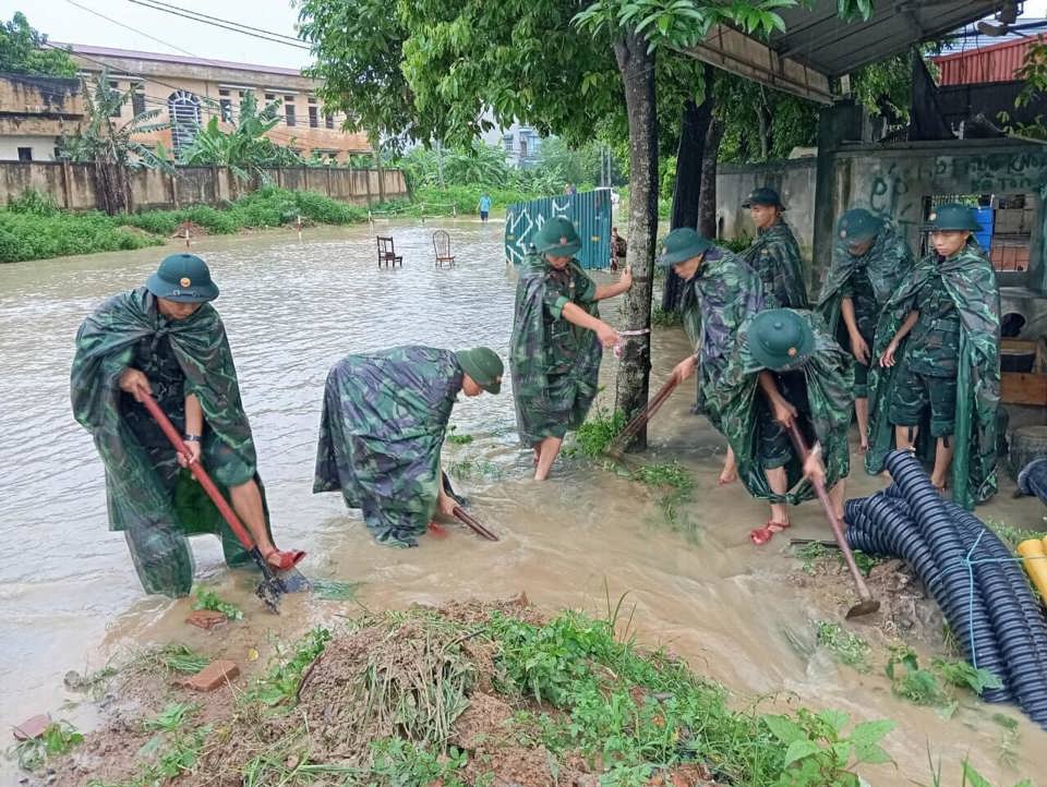 Lực lượng bộ đội khai th&ocirc;ng d&ograve;ng chảy gi&uacute;p&nbsp; hạ mực nước. Ảnh: Ban tuy&ecirc;n gi&aacute;o Thạch Thất.