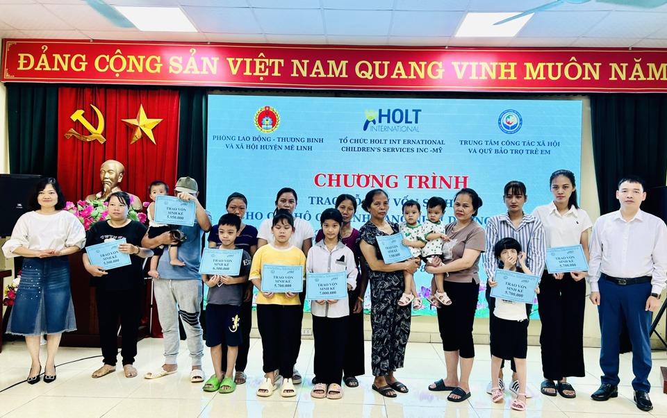 L&atilde;nh đạo Trung t&acirc;m C&ocirc;ng t&aacute;c x&atilde; hội v&agrave; Quỹ Bảo trợ trẻ em H&agrave; Nội v&agrave;&nbsp; đại diện Tổ chức Holt&nbsp;trao hỗ trợ vốn sinh kế cho c&aacute;c hộ gia đ&igrave;nh&nbsp;đang nu&ocirc;i dưỡng trẻ em c&oacute; ho&agrave;n cảnh kh&oacute; khăn. Ảnh: Trần Oanh.