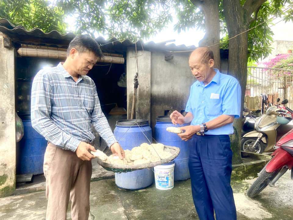 &Ocirc;ng Phạm Văn Ngọc - Trưởng th&ocirc;n Y&ecirc;n Ngưu, x&atilde; Tam Hiệp (b&igrave;a phải) kiểm tra chất lượng men rượu trước khi cho v&agrave;o ủ.