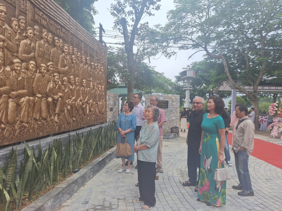 Trước giờ diễn ra lễ kh&aacute;nh th&agrave;nh c&ocirc;ng tr&igrave;nh, b&agrave; Đ&agrave;o Thị Ngọc Dung (đầu ti&ecirc;n từ tr&aacute;i sang) -vợ của đồng ch&iacute; Phạm Văn Th&aacute;i (b&iacute; danh Trần Ki&ecirc;n) ngắm nh&igrave;n bức ph&ugrave; đi&ecirc;u được tạc từ bức ảnh gốc m&agrave; gia đ&igrave;nh hiến tặng.