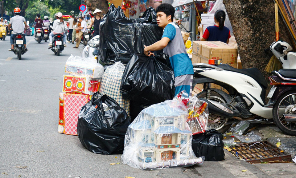 Người kinh doanh h&agrave;ng m&atilde; tr&ecirc;n phố H&agrave;ng M&atilde; vận chuyển h&agrave;ng tới người mua. Ảnh: Ho&agrave;i Nam