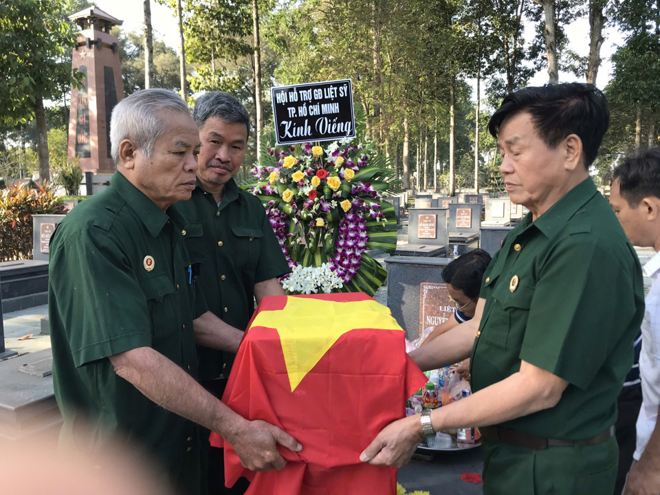 &Ocirc;ng Quản (b&igrave;a tr&aacute;i) c&ugrave;ng đồng đội t&igrave;m, đưa h&agrave;i cốt liệt sĩ hồi hương. Ảnh: Nh&acirc;n vật cung cấp.