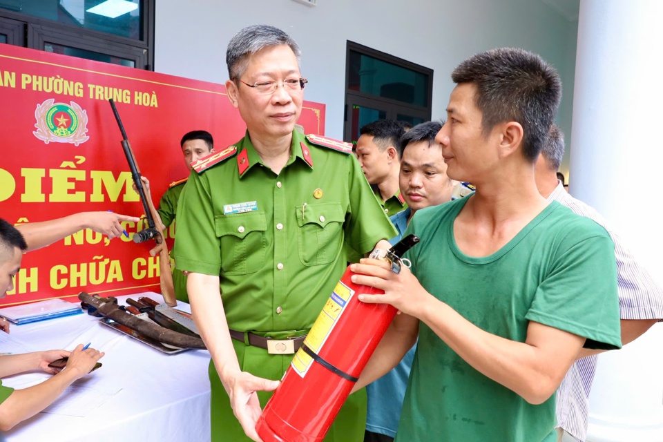 Đại t&aacute; Th&agrave;nh Ki&ecirc;n Trung - Trưởng C&ocirc;ng an quận Cầu Giấy trao b&igrave;nh cứu hoả cho người d&acirc;n tham gia đổi vũ kh&iacute;, vật liệu nổ.