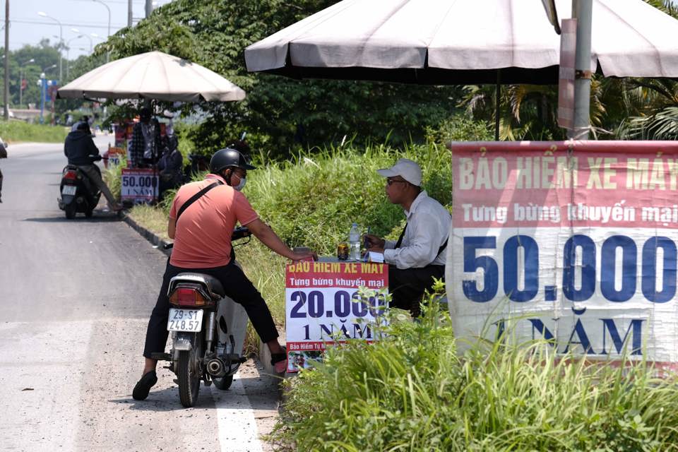 Người dân tìm mua bảo hiểm xe máy trên đường Võ Văn Kiệt, huyện Đông Anh. Ảnh: Công Hùng