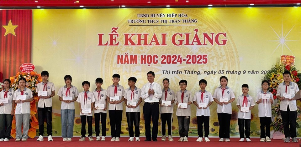 Chủ tịch UBND huyện Ho&agrave;ng C&ocirc;ng Bộ trao qu&agrave; cho c&aacute;c em học sinh vượt kh&oacute; vươn l&ecirc;n trong học tập.