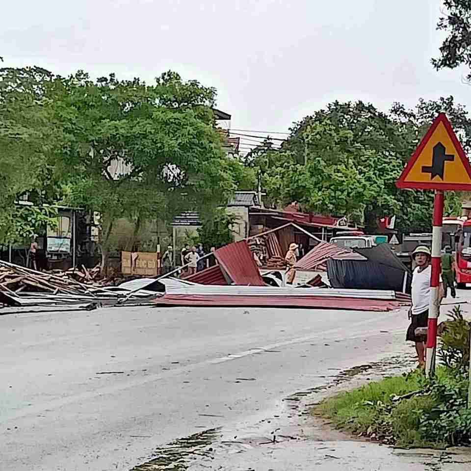 Nước ngập khiến c&aacute;c phương tiện kh&ocirc;ng thể lưu th&ocirc;ng qua ngầm tr&agrave;n, gi&oacute; thổi bay một m&aacute;i che t&ocirc;n của xưởng gỗ b&oacute;c. Ảnh: Người d&acirc;n cung cấp.