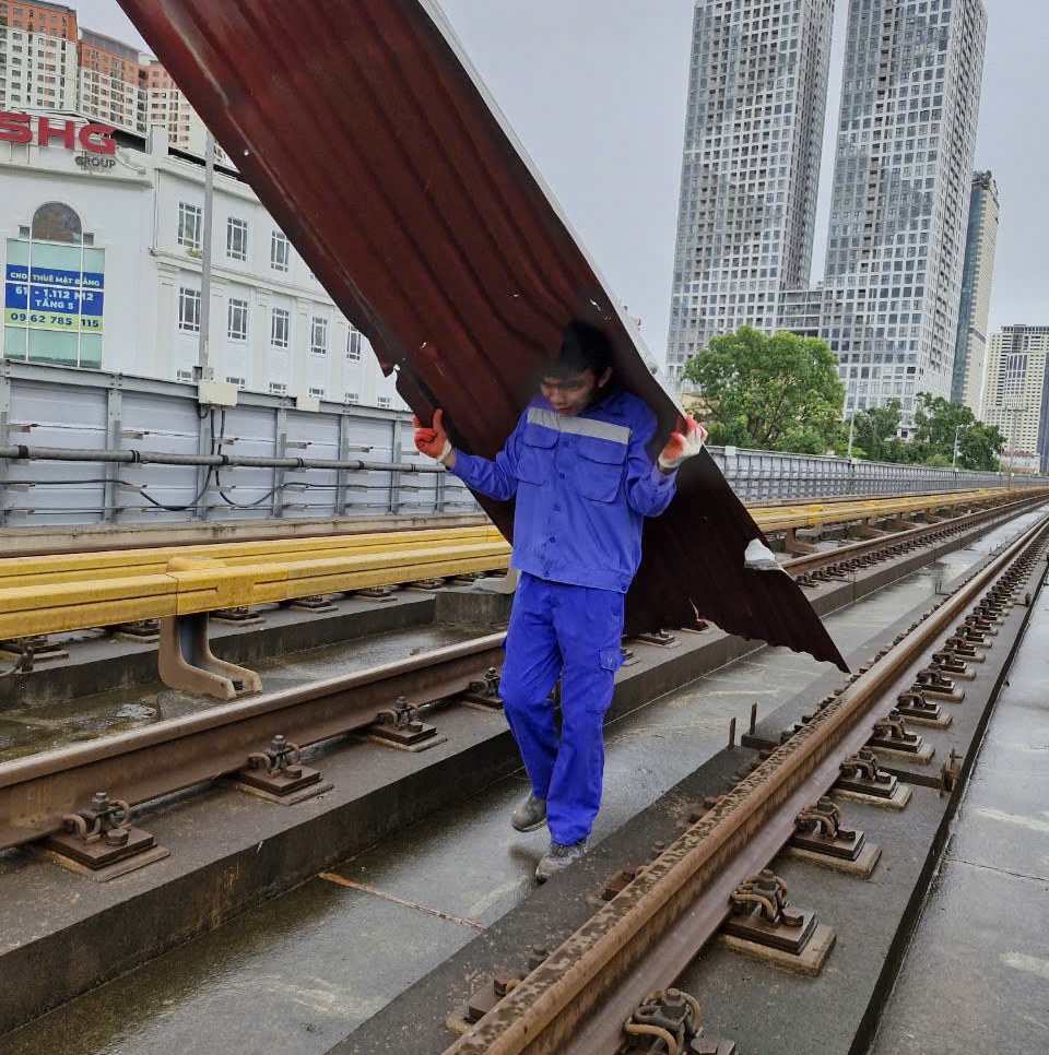 C&ocirc;ng nh&acirc;n đang tiến h&agrave;nh dọn dẹp đường ray t&agrave;u điện C&aacute;t Linh - H&agrave; Đ&ocirc;ng.