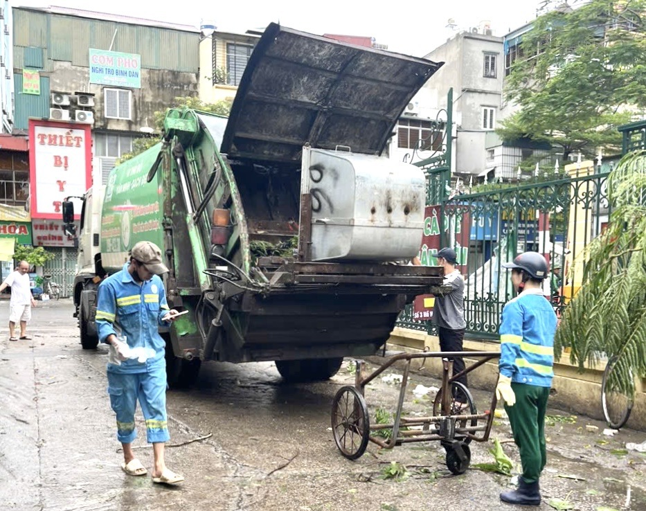 C&ocirc;ng nh&acirc;n vệ sinh m&ocirc;i trường dọn dẹp r&aacute;c thải tr&ecirc;n c&aacute;c tuyến phố sau b&atilde;o.