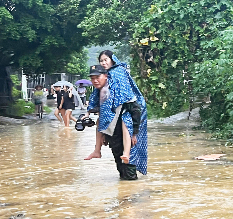 Chiến sĩ qu&acirc;n đội c&otilde;ng một bệnh nh&acirc;n từ xuồng về nh&agrave;.