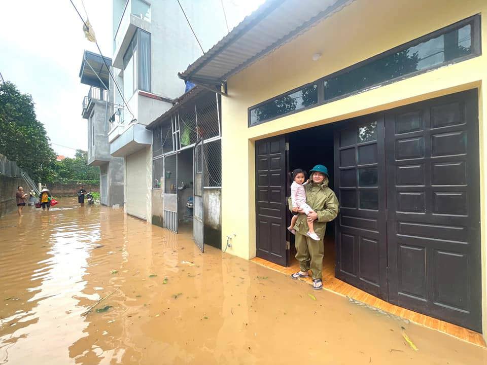 Cán b&ocirc;̣ c&ocirc;ng an huy&ecirc;̣n Đan Phượng h&ocirc;̃ trợ người d&acirc;n di dời người và tài sản đ&ecirc;́n nơi an toàn.