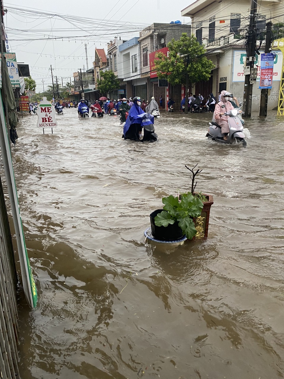 Người v&agrave; xe bơi trong biển nước tr&ecirc;n tuyến đường li&ecirc;n x&atilde; Nam Trung, huyện Tiền Hải trong cơn mưa lớn đ&ecirc;m qua v&agrave; s&aacute;ng nay (10/9).